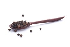 Close up black peper in wooden spoon pile on white background.